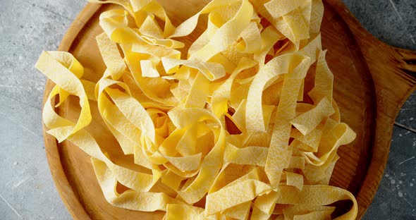 Dry Fettuccine Pasta on a Cutting Board Rotates Slowly. 