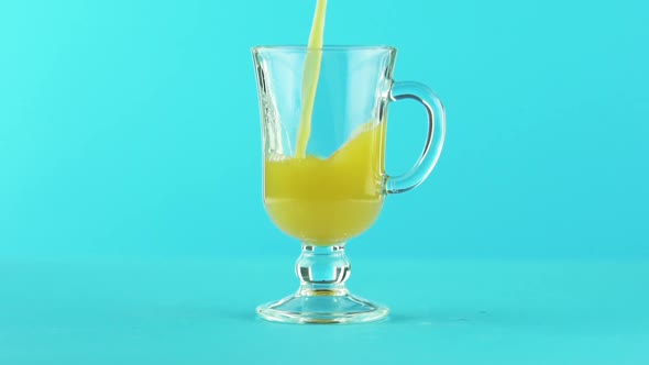 Slow Motion Close-up Shot of Fruit Orange Multifruit Juice Cold Beverage Drink Pooring Glass Mug 