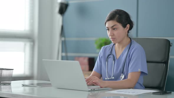 Indian Female Doctor Shaking Head as No Sign while using Laptop in Office