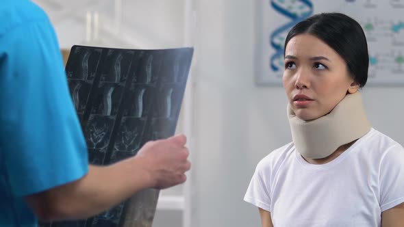 Sad Woman in Foam Cervical Collar at Doctors Appointment, Negative X-Ray Result