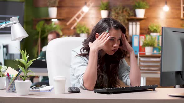 Stressed Woman Having a Headache While Working in the Office