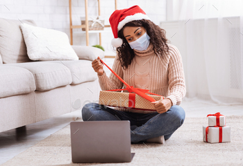 Black Lady In Mask Opening Present Box And Using Laptop / Photodune, Misc