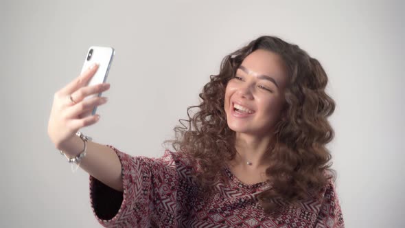 The girl emotionally communicates by video call using a modern smartphone