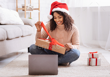 Black Woman Opening Present Box And Using Laptop Computer / Photodune, Misc