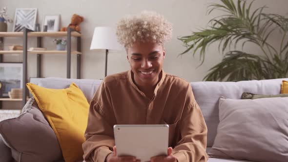 African Female Sit on Couch Talk to Family Remotely Using Tablet