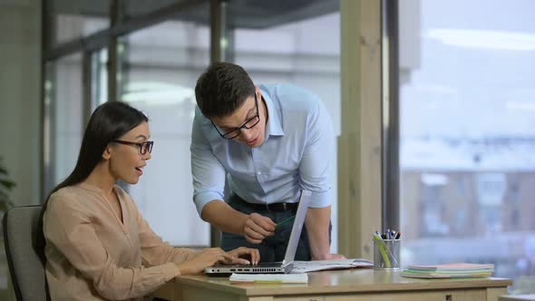 Team of Marketers Reading Feedback About Company on Laptop, Rejoicing at Results