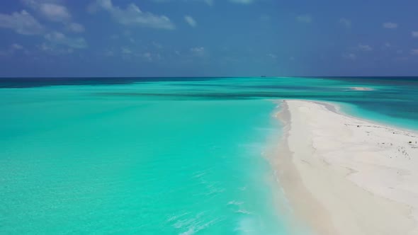 Aerial panorama of tranquil tourist beach break by clear ocean with white sand background of adventu