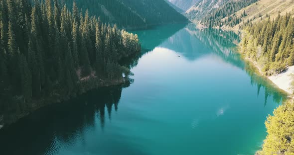 Beautiful landscape of mountain lake, Emerald water surrounded by coniferous forest, autumn grass