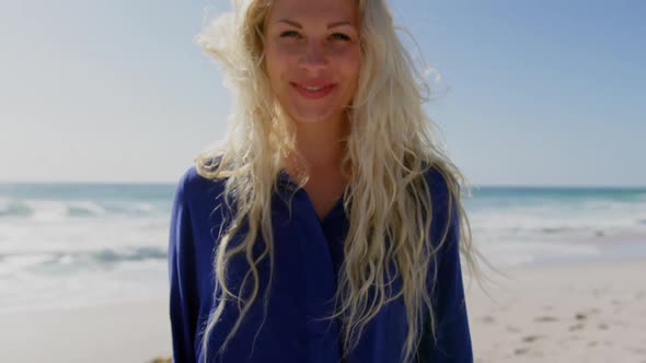 Woman standing on beach in the sunshine 