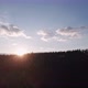 The setting sun shimmers among the trees on a hill in the mountains. Magic hour - VideoHive Item for Sale