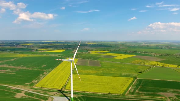 The wind power stations on the spring field, view from a drone