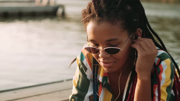 Relaxed Afroamerican Woman Lisent Music Using Smart Phone