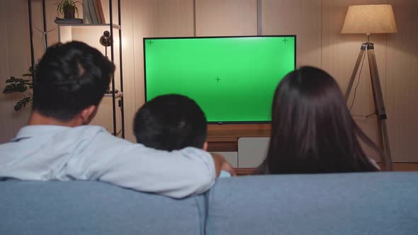 Back View Of Asian Family, Father, Mother And Little Son Watching Tv With Mock Up Green Screen