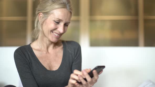 Mature woman texting on her smart phone