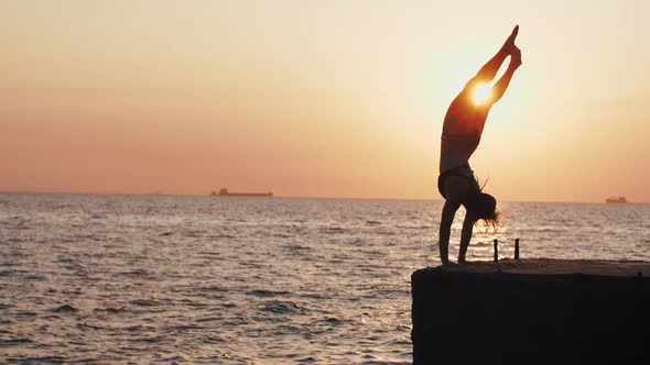 Young Youman Jumping and Doing Trick From Sea Pier During Beautiful Sunrise Slow Motion