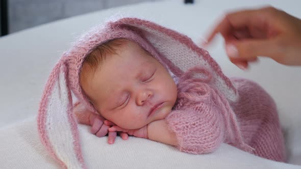 Nice Little Caucasian Newborn Baby in Adorable Funny Hare Rabbit Suit Sleeping