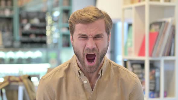 Portrait of Annoyed Young Man Shouting Screaming