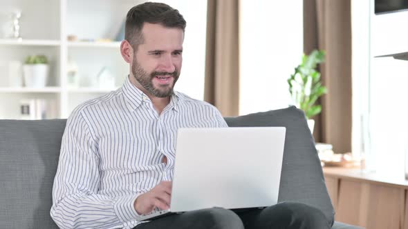 Excited Businessman Celebrating Success on Laptop at Home 