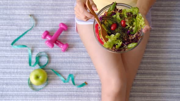 Young woman eating homemade healthy salad at home