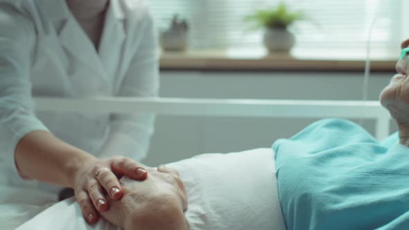 Female Doctor Supporting Elderly Woman in Hospital