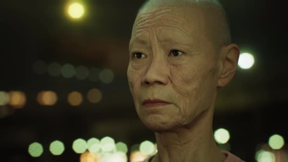 Old Asian Woman in City at Night alt