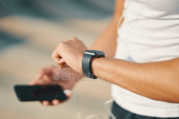 gestures on a wearable smart watch computer device, hands and watch close up, unrecognizable. Technology, gadget in sport.