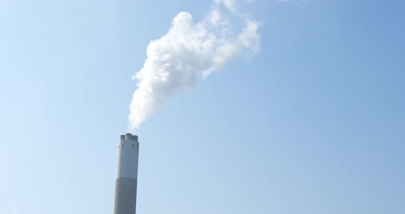 Air pollution by smoke coming out of the factory chimney