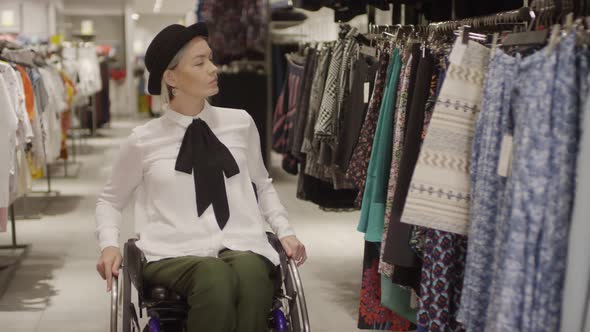 Woman in Wheelchair Shopping for Skirt in Clothing Store