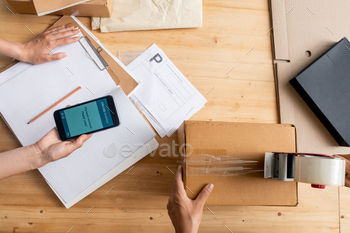 Female hands holding smartphone with online banking page over document