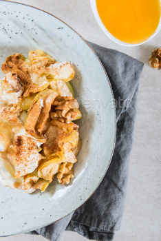 topped with walnuts, coconut yogurt and honey, grey background, top view