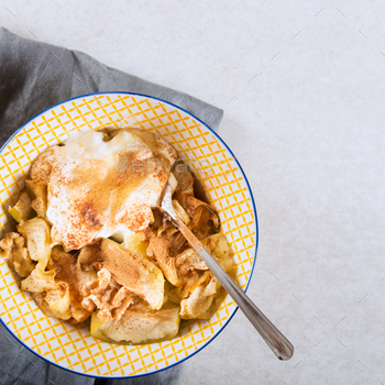 topped with walnuts, coconut yogurt and honey, grey background, top view
