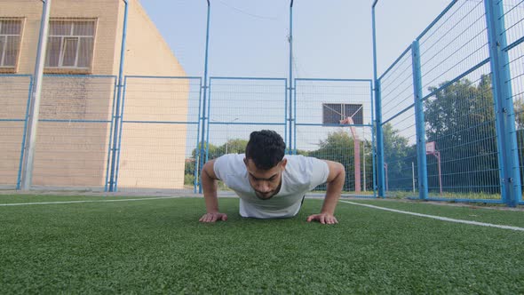 Handsome Strong Middle Eastern Male Athlete or Trainer Slowly Demonstrates Correct Pushup Technique