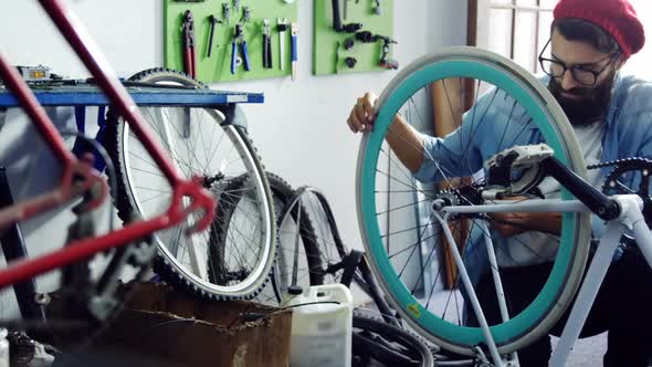 Mechanic repairing bicycle in workshop