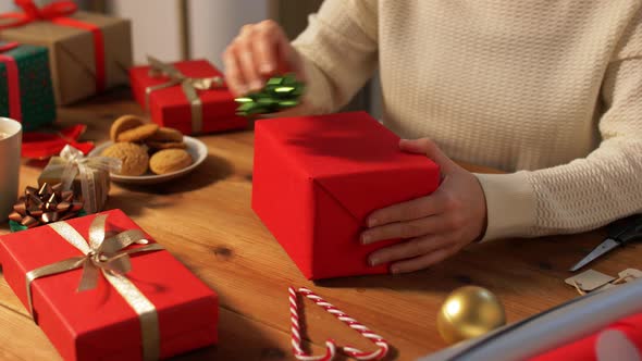 Woman Wrapping Christmas Gift Into Paper at Home