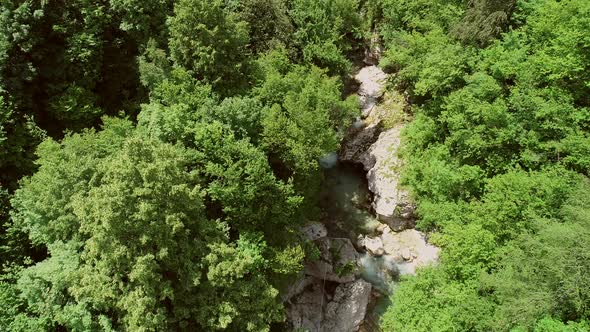 Aerial view of a person going across the Soca River on a zip line in Slovenia.