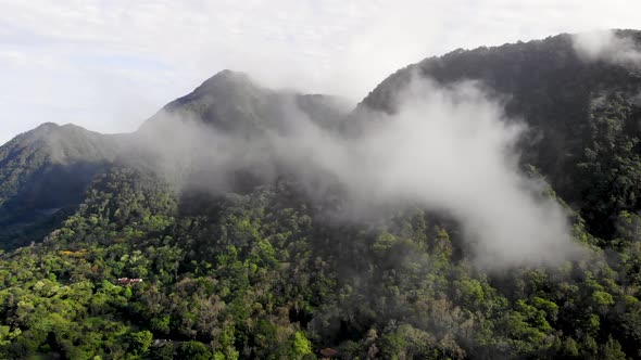 Clouds over Valle de Anton volcanic crater walls in central Panama extinct volcano, Aerial pan right