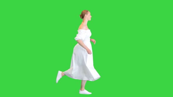 Young Woman in White Dress Running on a Green Screen Chroma Key