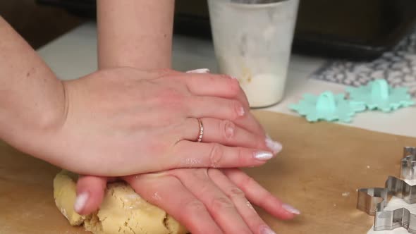 A Woman Sprinkles Flour On A Lump Of Dough.