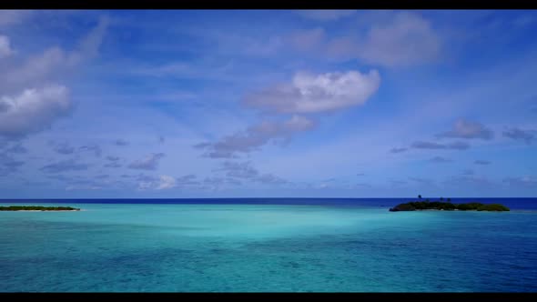 Aerial drone shot scenery of paradise coastline beach break by clear lagoon with white sand backgrou