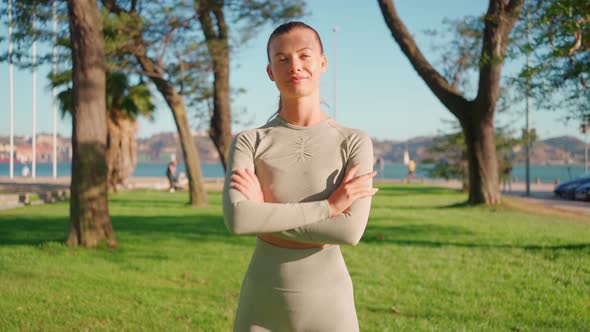 Sportswoman Standing in Summer Park After Morning Workout Arms Crossed Looking at Camera