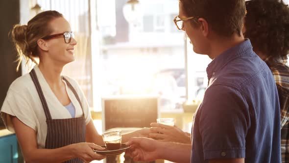 Waitress serving black tea to two friends