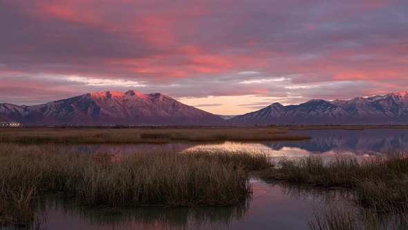 Colorful sunset over the marsh of Utah Lake reflecting the snow capped mountains