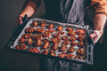 Baking Sheet with Oven Baked Tomatoes with Oil and Thyme in a Hands - PhotoDune Item for Sale