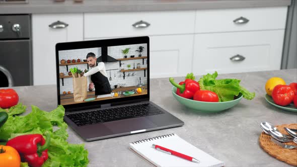 Close Up Laptop with Man Chef in Screen Tells Removes Vegetables From Paper Bag