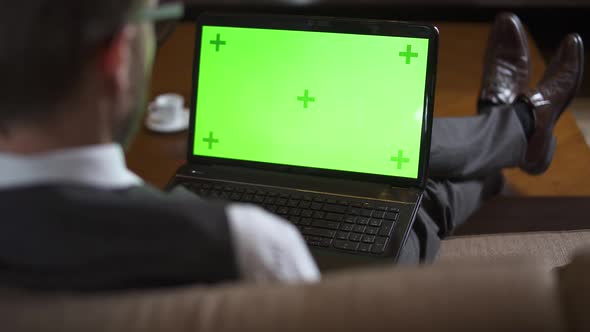 Businessman in Glasses Working at a Laptop with Chroma Key Screen Man in the Suit Sitting on the