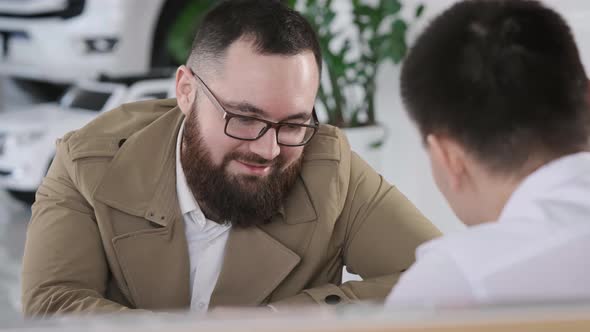 The Client is a Man at the Table of the Sales Manager Discussing the Terms of the Contract