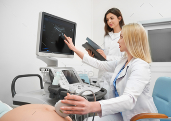 sing during ultrasound diagnostic of pregnant woman. Professional doctors examining baby in belly. Concept of medical procedure and health.