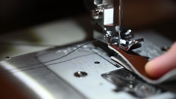 male hand, sewing, close-up of the needle bobbing up and down.  Shot with a macro lens