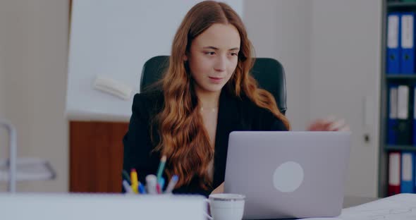 Tensed Businesswoman Working on Laptop in Office