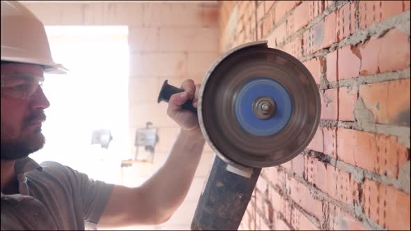 A construction worker with a circular saw in construction site.